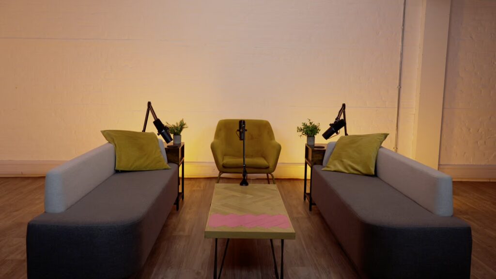 Outset Studio with grey sofas, yellow arm chairs and microphones